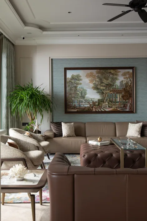 Elegant living room featuring plush mint green and cream velvet sofas, round marble-top coffee tables, and large windows with sheer drapes.