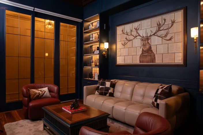 Cosy family lounge featuring a grey fabric sectional sofa, textured wallpaper, and a wall-mounted media console.