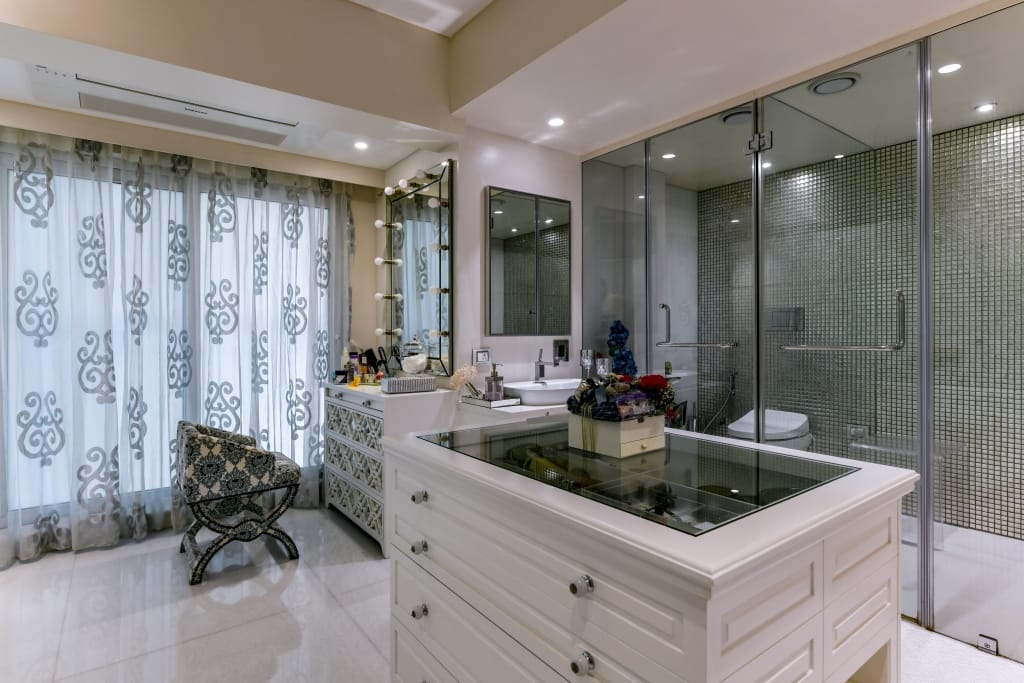 Luxury master bathroom with white statuario marble walls, a double floating wash vanity, and glass-enclosed shower.